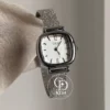 A delicate blend of modern elegance and vintage charm, this silver sparkle oval women's watch is designed to make a subtle yet striking statement. Featuring a polished oval case and a minimalist white dial, the design is elevated by a shimmering textured strap that catches the light beautifully with every movement.