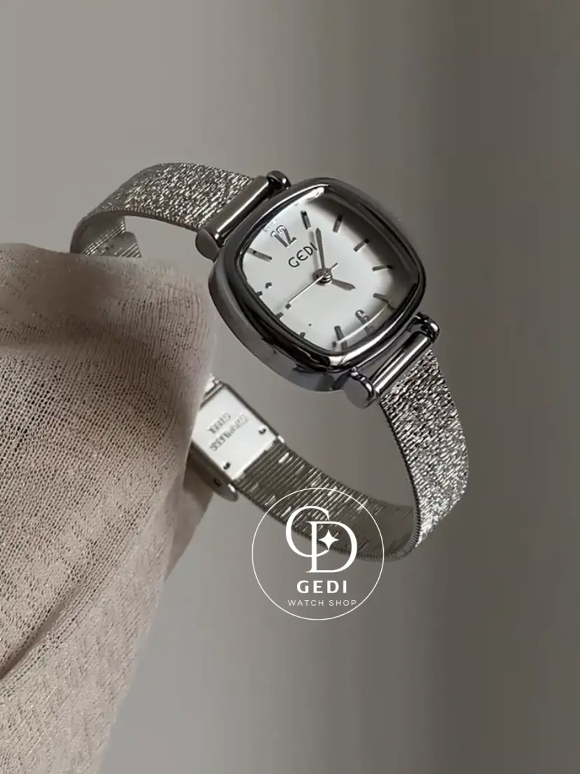 A delicate blend of modern elegance and vintage charm, this silver sparkle oval women's watch is designed to make a subtle yet striking statement. Featuring a polished oval case and a minimalist white dial, the design is elevated by a shimmering textured strap that catches the light beautifully with every movement.