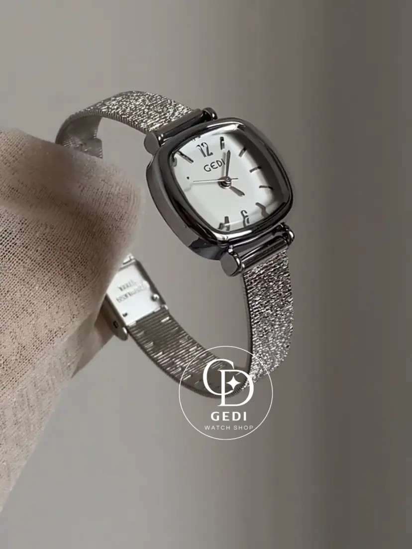 A delicate blend of modern elegance and vintage charm, this silver sparkle oval women's watch is designed to make a subtle yet striking statement. Featuring a polished oval case and a minimalist white dial, the design is elevated by a shimmering textured strap that catches the light beautifully with every movement.