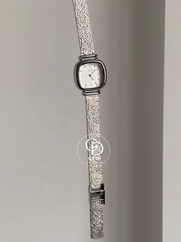 A delicate blend of modern elegance and vintage charm, this silver sparkle oval women's watch is designed to make a subtle yet striking statement. Featuring a polished oval case and a minimalist white dial, the design is elevated by a shimmering textured strap that catches the light beautifully with every movement.
