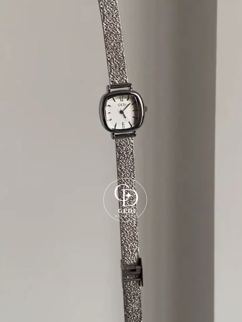 A delicate blend of modern elegance and vintage charm, this silver sparkle oval women's watch is designed to make a subtle yet striking statement. Featuring a polished oval case and a minimalist white dial, the design is elevated by a shimmering textured strap that catches the light beautifully with every movement.