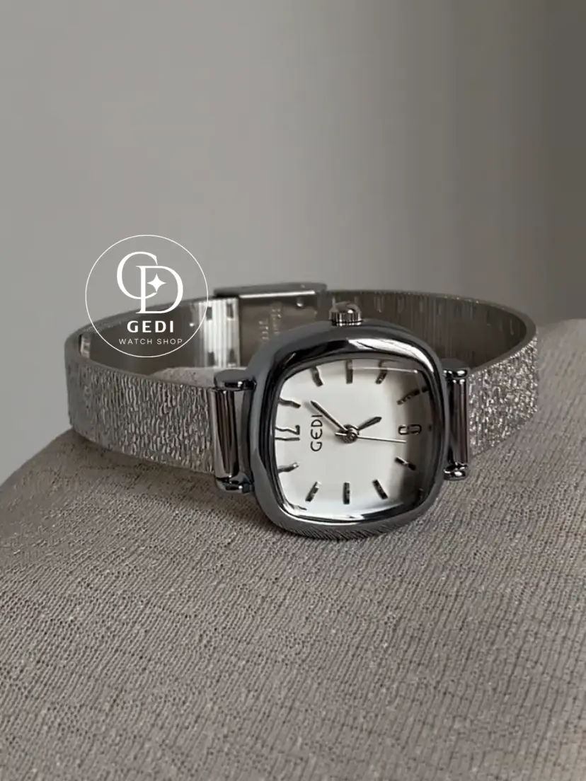 A delicate blend of modern elegance and vintage charm, this silver sparkle oval women's watch is designed to make a subtle yet striking statement. Featuring a polished oval case and a minimalist white dial, the design is elevated by a shimmering textured strap that catches the light beautifully with every movement.
